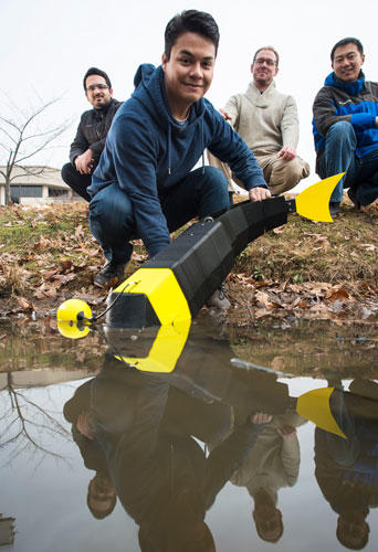 Mason students prepare to launch robot fish into a lake